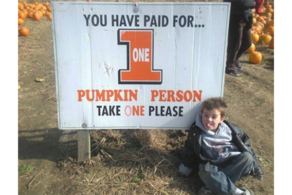 boy sitting in front of sign