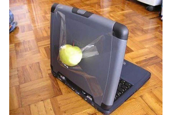 green apple taped to a laptop computer